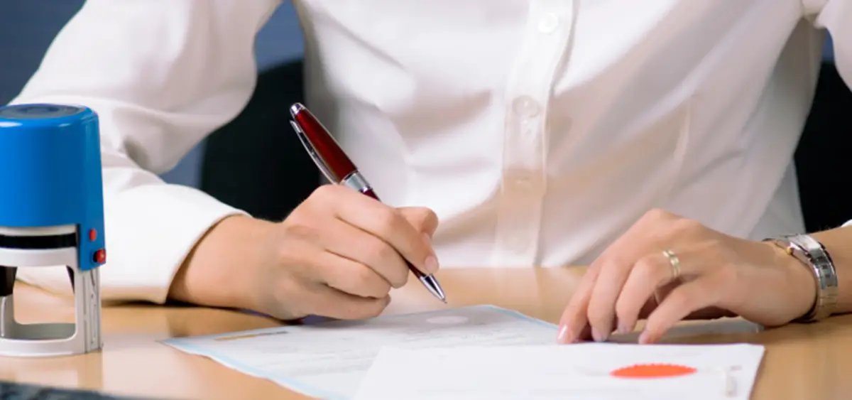 Illustrative reference image: preparing a written application at a desk