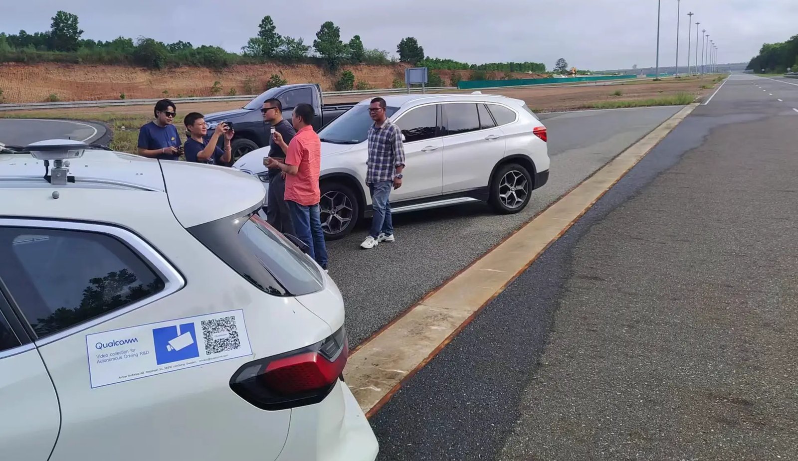 Field team beside instrumented test vehicles on a test road